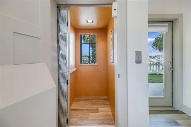 a view of a hallway with wooden floor and a door