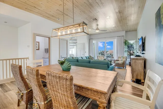 a view of a dining room with furniture a chandelier and wooden floor