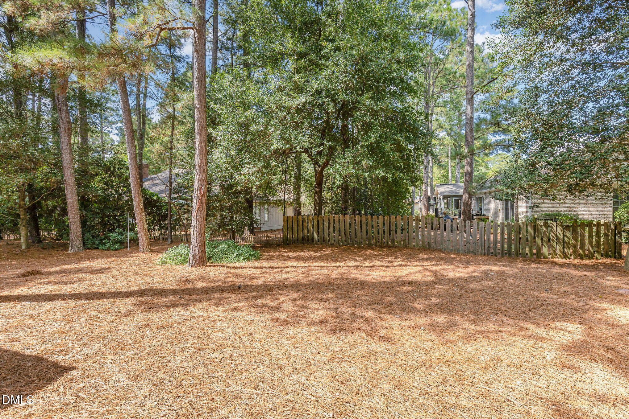 5 Pinyon Lane Pinehurst, NC 28374 - Photo 37 of 37 a backyard of a house with large trees and wooden fence