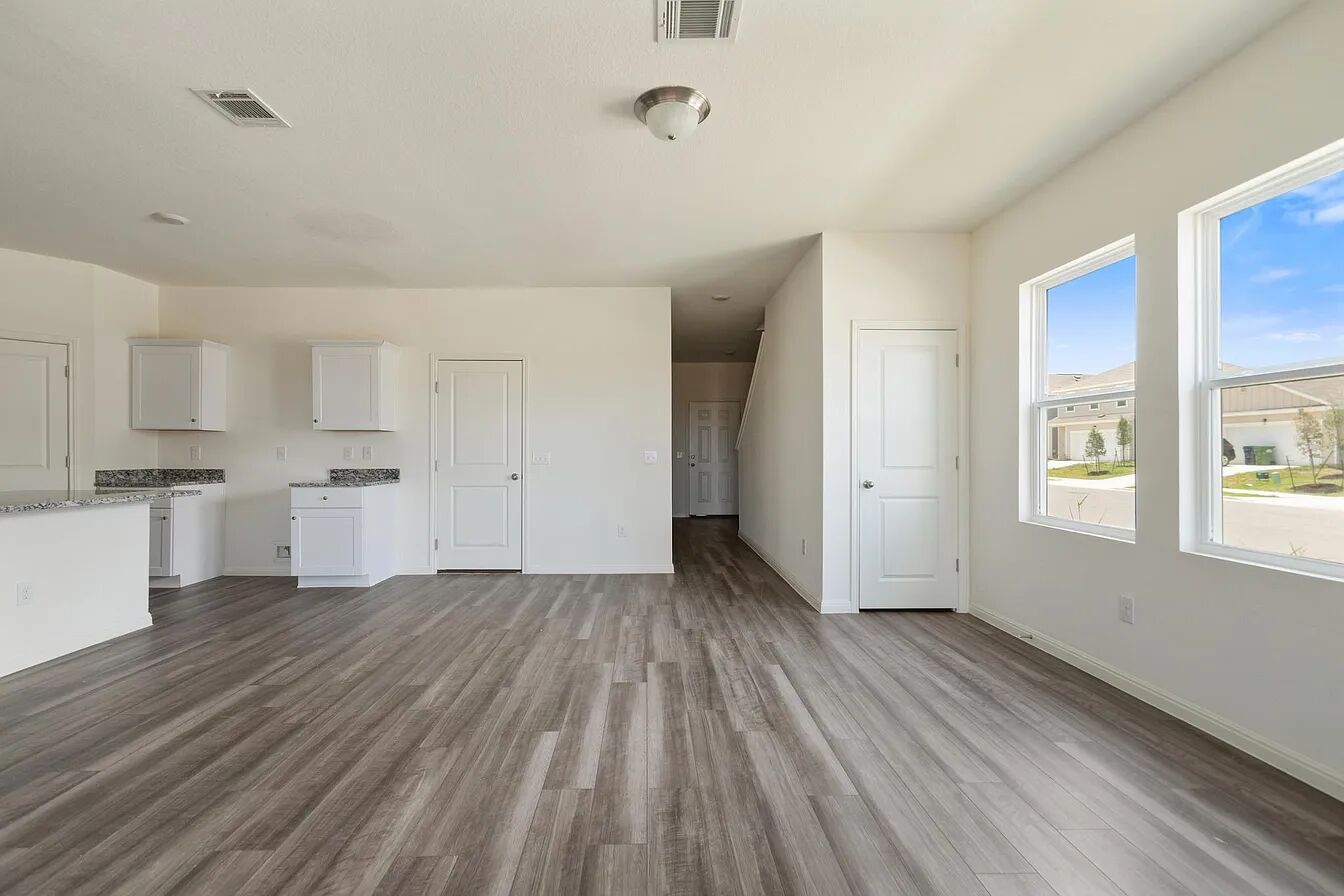 101 Aoudad Road Hutto, TX 78634 - Photo 13 of 39 Luminous living area with modern flooring and expansive windows creates an inviting atmosphere.