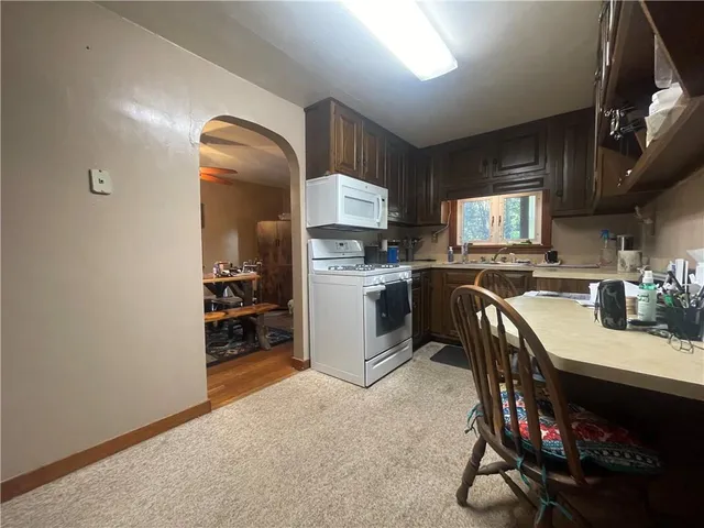 a kitchen with a sink appliances cabinets and a counter top space