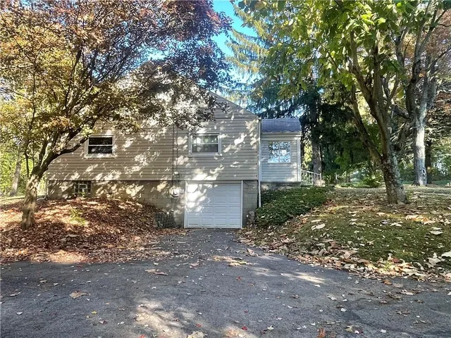 a front view of a house with a tree