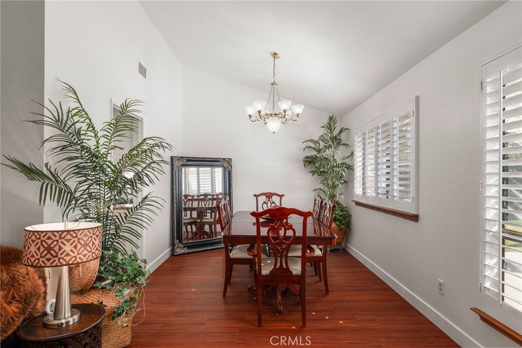 9637 Apricot Avenue Rancho Cucamonga, CA 91737 - Photo 11 of 44 a dining room with furniture wooden floor a potted plant and a chandelier