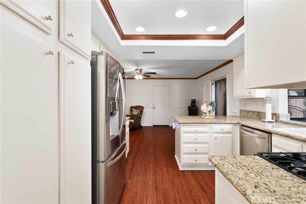 9637 Apricot Avenue Rancho Cucamonga, CA 91737 - Photo 12 of 44 a kitchen with a refrigerator and white cabinets