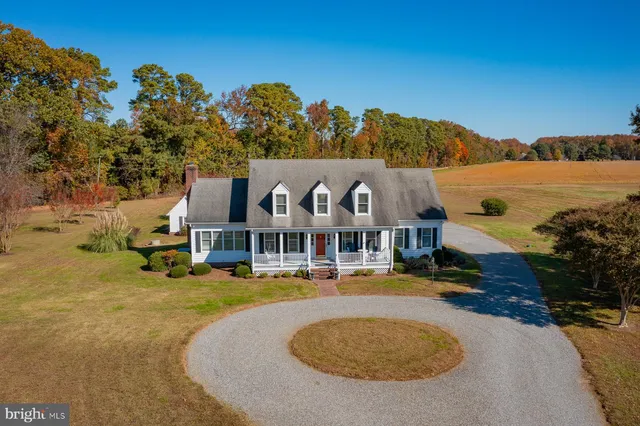 a kitchen with stainless steel appliances kitchen island granite countertop a refrigerator a stove a sink dishwasher and white cabinets with wooden floor