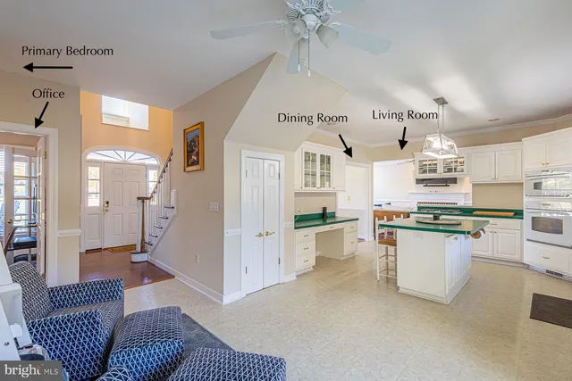 a kitchen with a refrigerator a stove top oven a sink a dining table and chairs