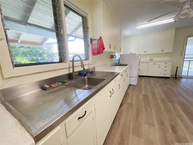 a bathroom with a sink and a large mirror next to a window