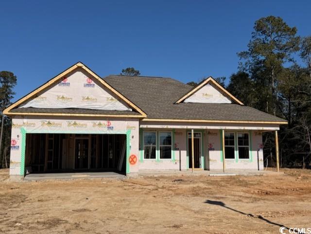 Unfinished property featuring a garage and covered porch