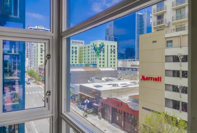 a living room with furniture large windows and wooden floor