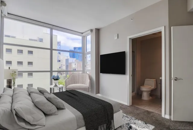 a bedroom with a bed and a flat tv screen in it