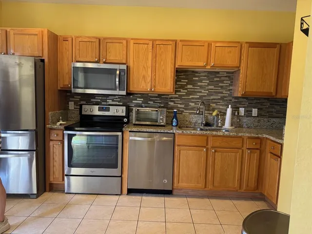 a kitchen with stainless steel appliances a refrigerator sink and microwave