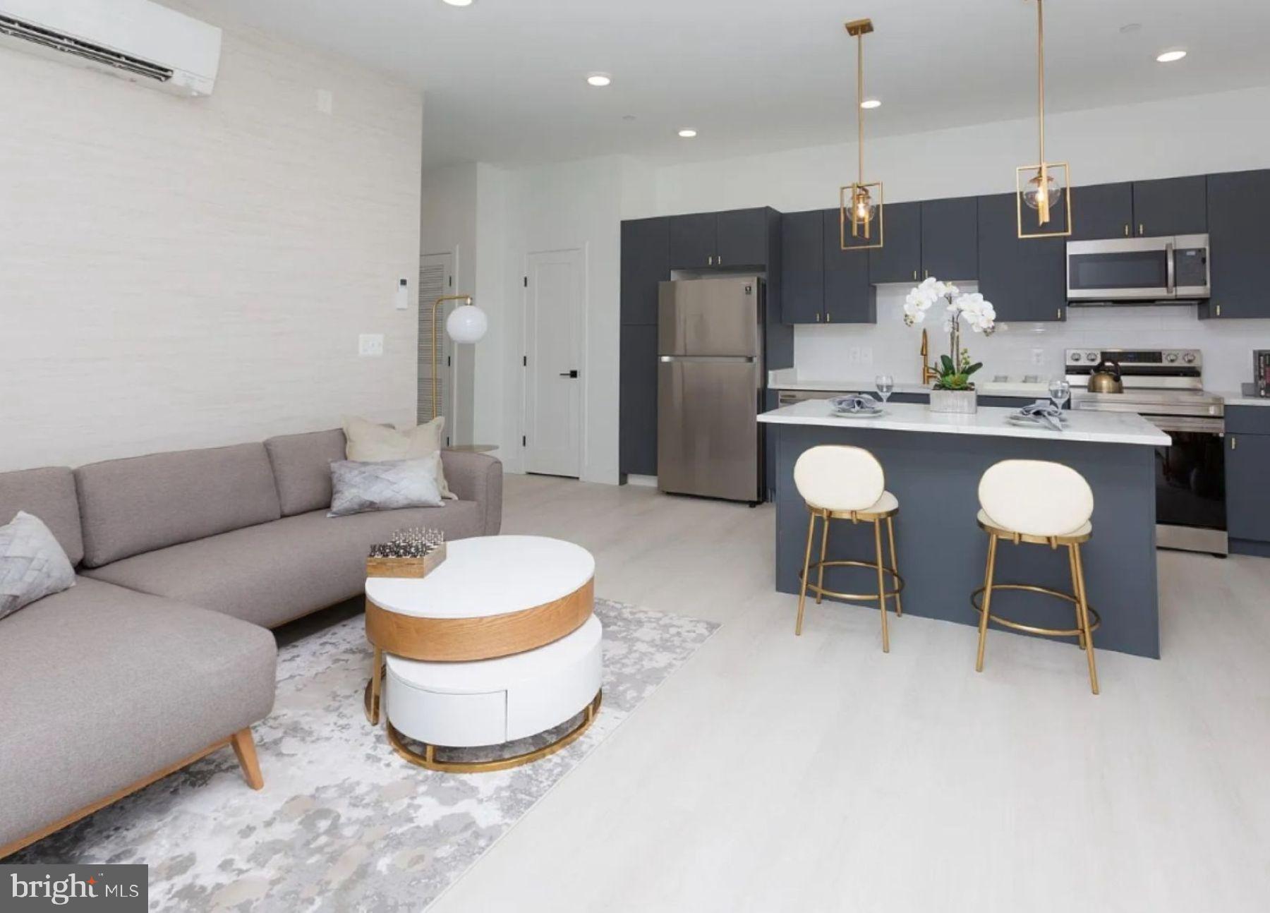 a living room with kitchen island furniture and a view of kitchen