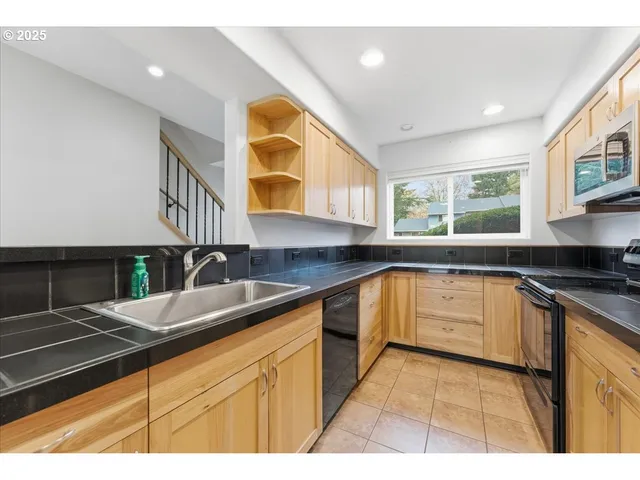 a kitchen with stainless steel appliances granite countertop a sink and a stove