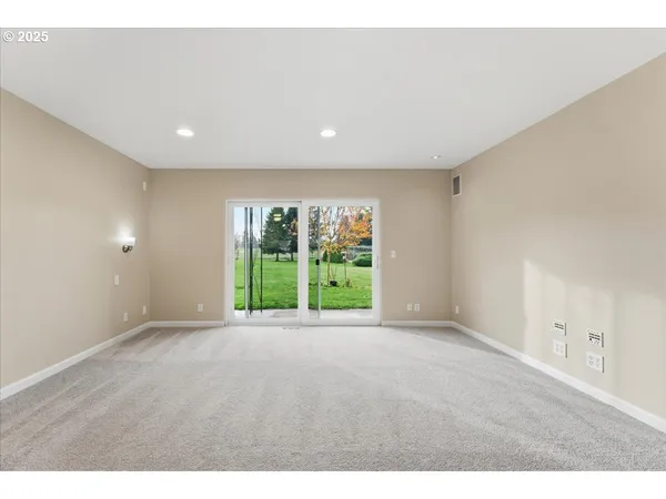 a view of an empty room with yard and balcony