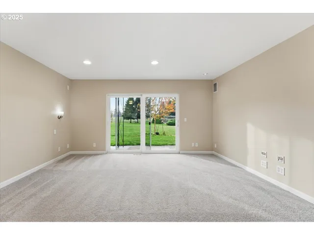 a view of an empty room with yard and balcony