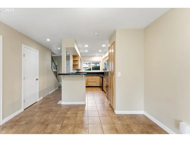 a view of a kitchen with kitchen island a sink stainless steel appliances and cabinets