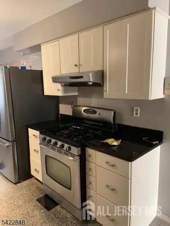 a kitchen with granite countertop white cabinets and black appliances