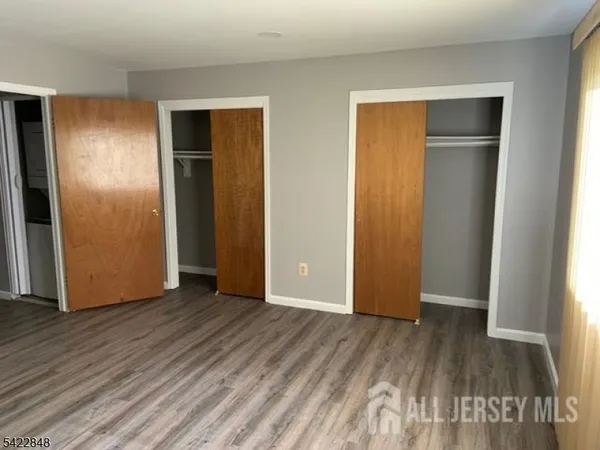 an empty room with wooden floor and closet