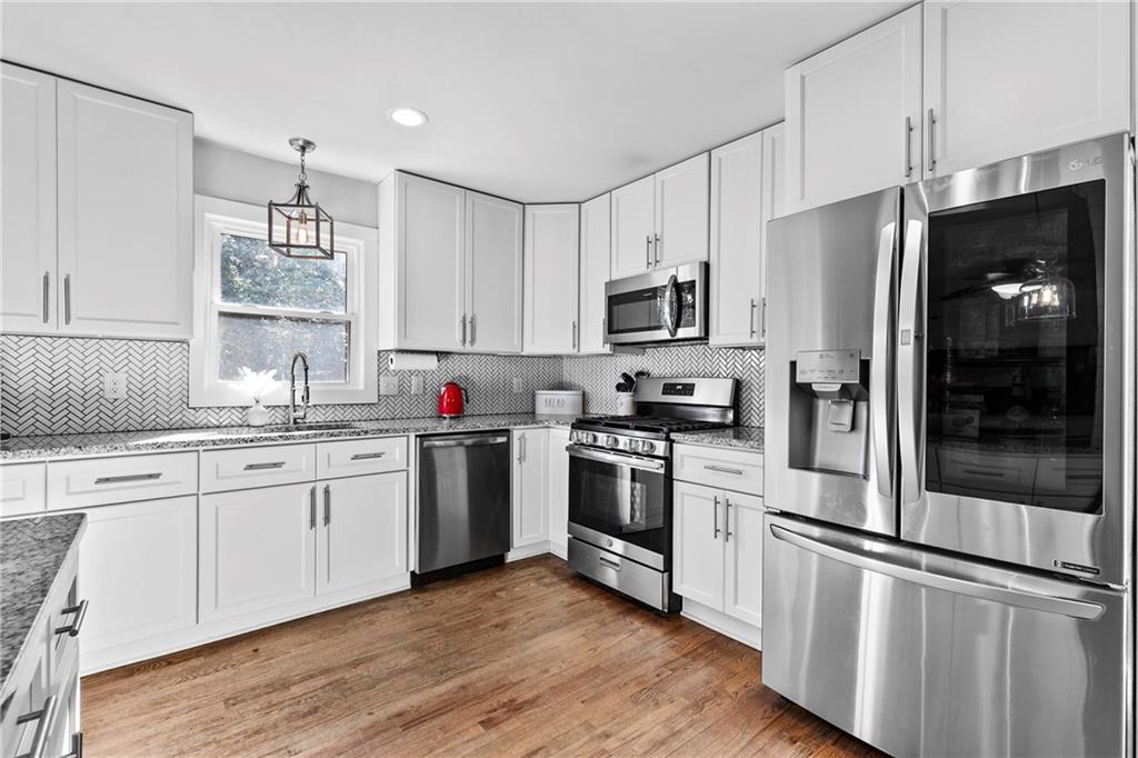 208 Shadowlawn Road Southeast Marietta, GA 30067 - Photo 8 of 25 a kitchen with granite countertop stainless steel appliances a sink cabinets and wooden floor