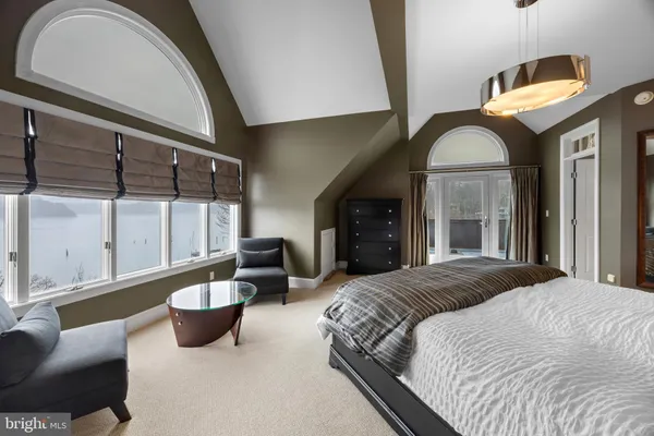 a spacious bedroom with a bed and large windows