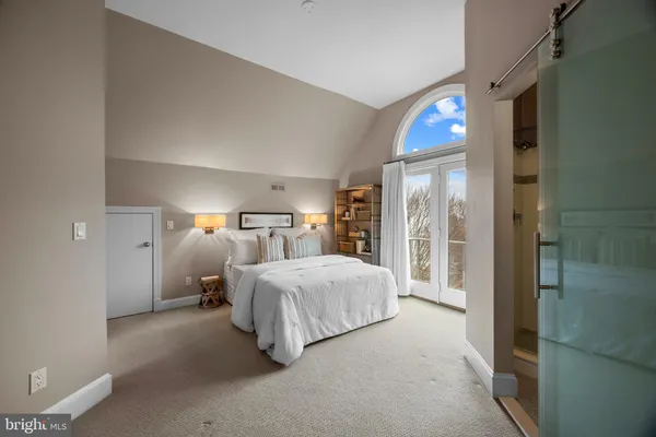 a bedroom with a bed and a lamp on dresser