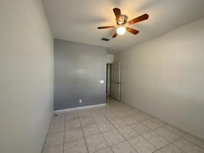 140 Baldwin Boulevard Greenacres, FL 33463 - Photo 4 of 12 an empty room with chandelier fan and windows