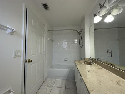 140 Baldwin Boulevard Greenacres, FL 33463 - Photo 7 of 12 a bathroom with a granite countertop sink a shower and a mirror