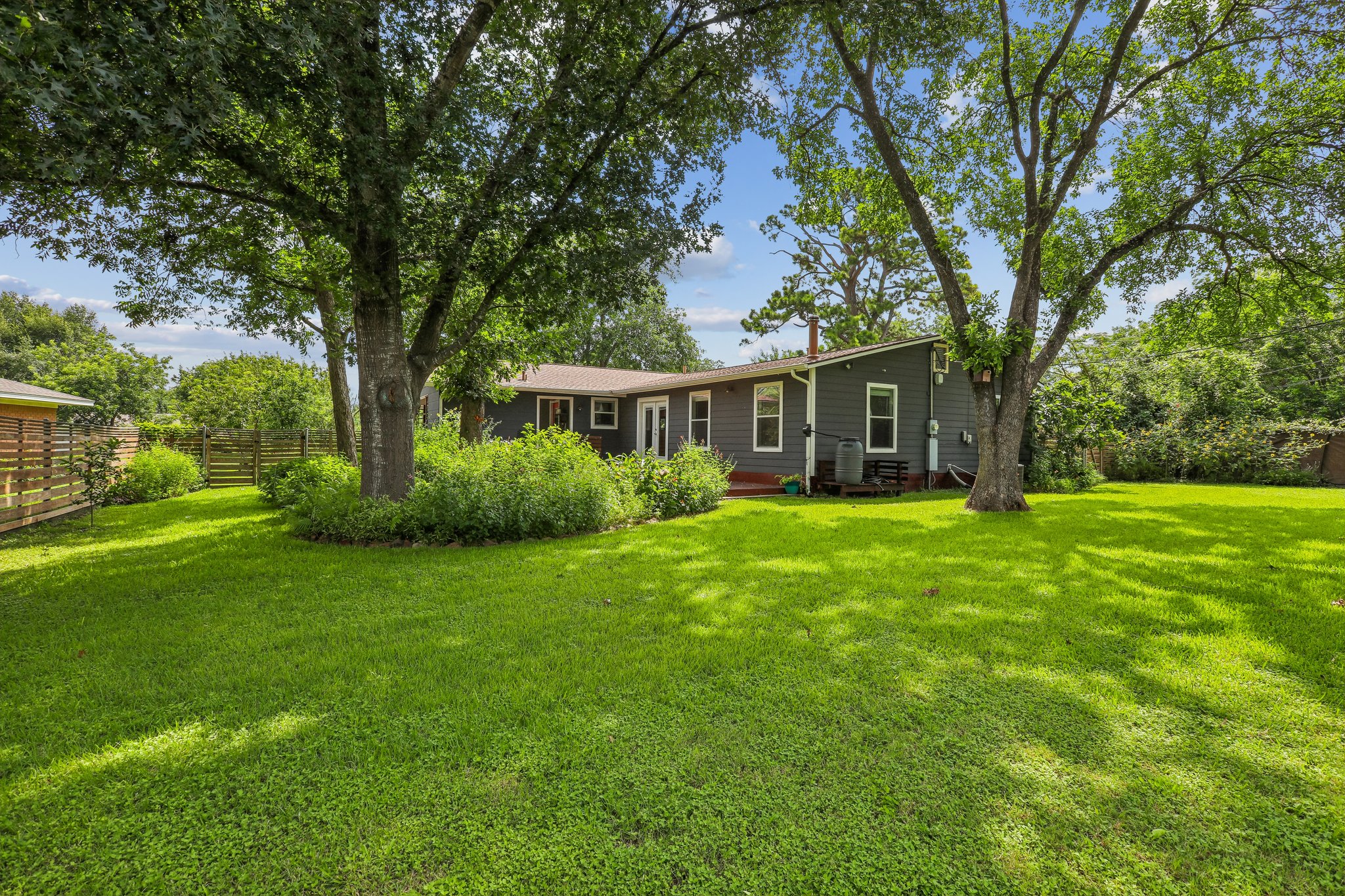 1114 West 2nd Street Elgin, TX 78621 - Photo 24 of 31 A deep, verdant yard provides ample space for recreation and outdoor enjoyment.