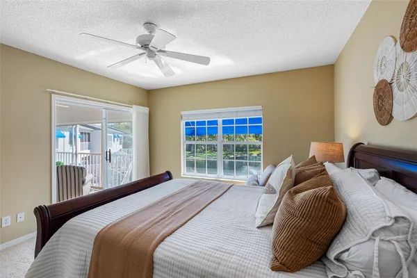 a bedroom with a bed a couch and a potted plant