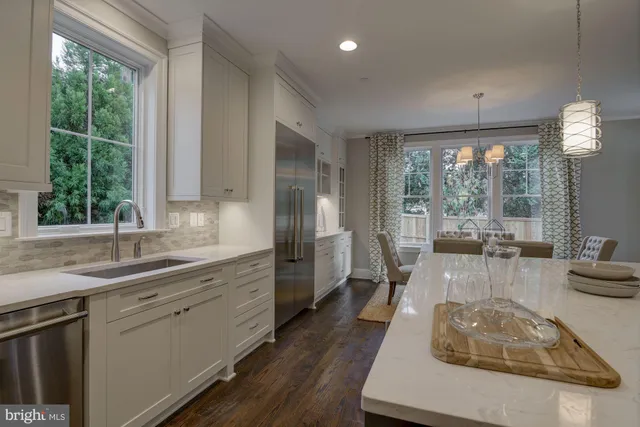 a kitchen with sink refrigerator and large window