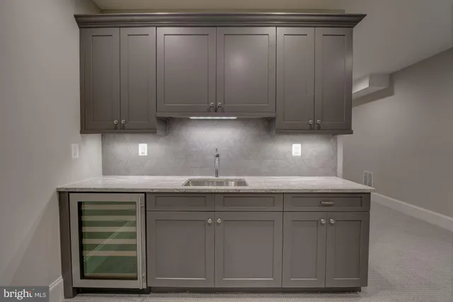 a kitchen with granite countertop a sink cabinets and stainless steel appliances