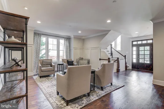 a living room with furniture a wooden floor and a large window