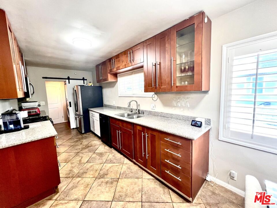 4340 Sepulveda Boulevard Sherman Oaks, CA 91403 - Photo 21 of 30 a large kitchen with stainless steel appliances granite countertop a sink stove and refrigerator