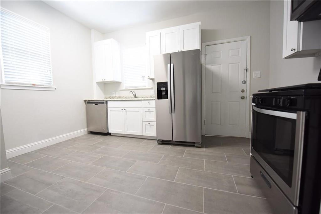 4612 Junius Street, Unit B Dallas, TX 75246 - Photo 8 of 14 a kitchen with a refrigerator sink and cabinets