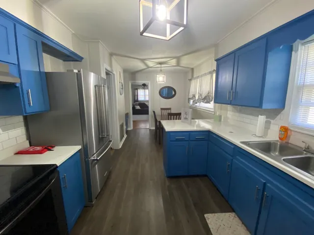 a kitchen with stainless steel appliances sink stove refrigerator and cabinets