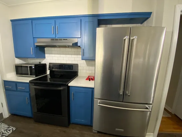 a kitchen with a refrigerator and a stove