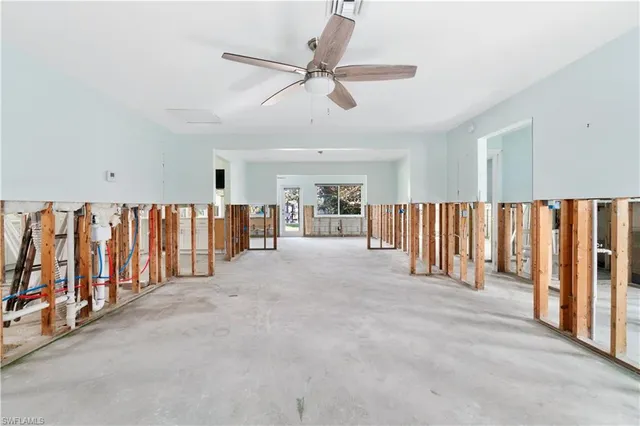 a view of an empty room with a window and fireplace