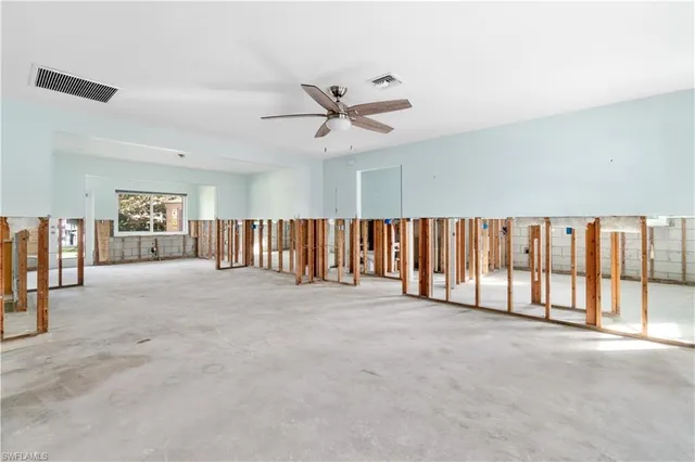 an empty room with windows & cabinet