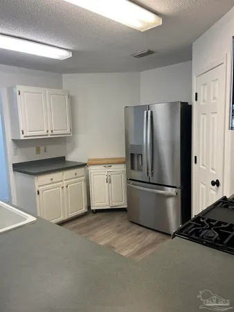 a kitchen with a refrigerator sink and cabinets