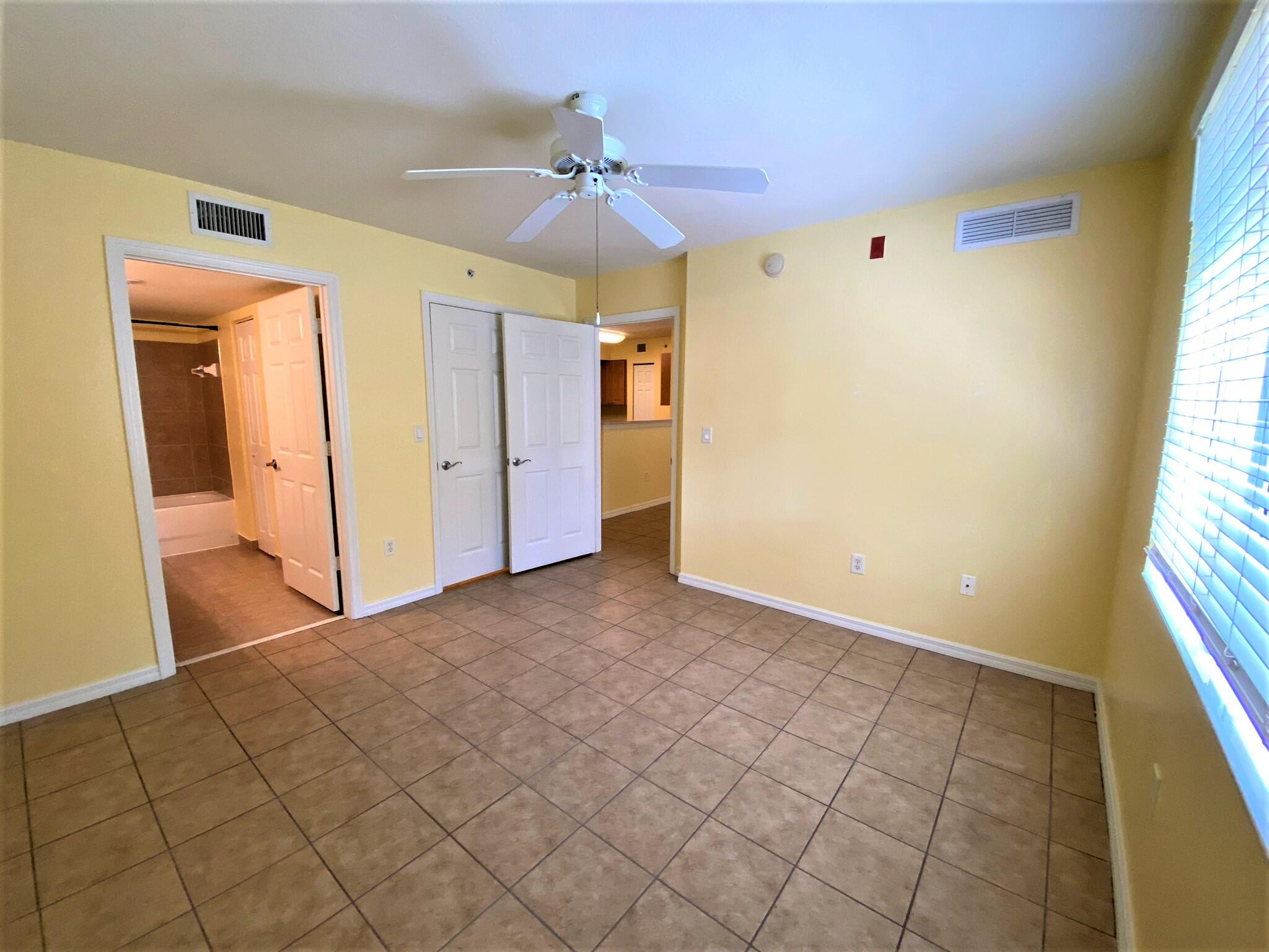 6768 Heritage Grande, Unit 106 Boynton Beach, FL 33437 - Photo 16 of 56 an empty room with windows and chandelier fan