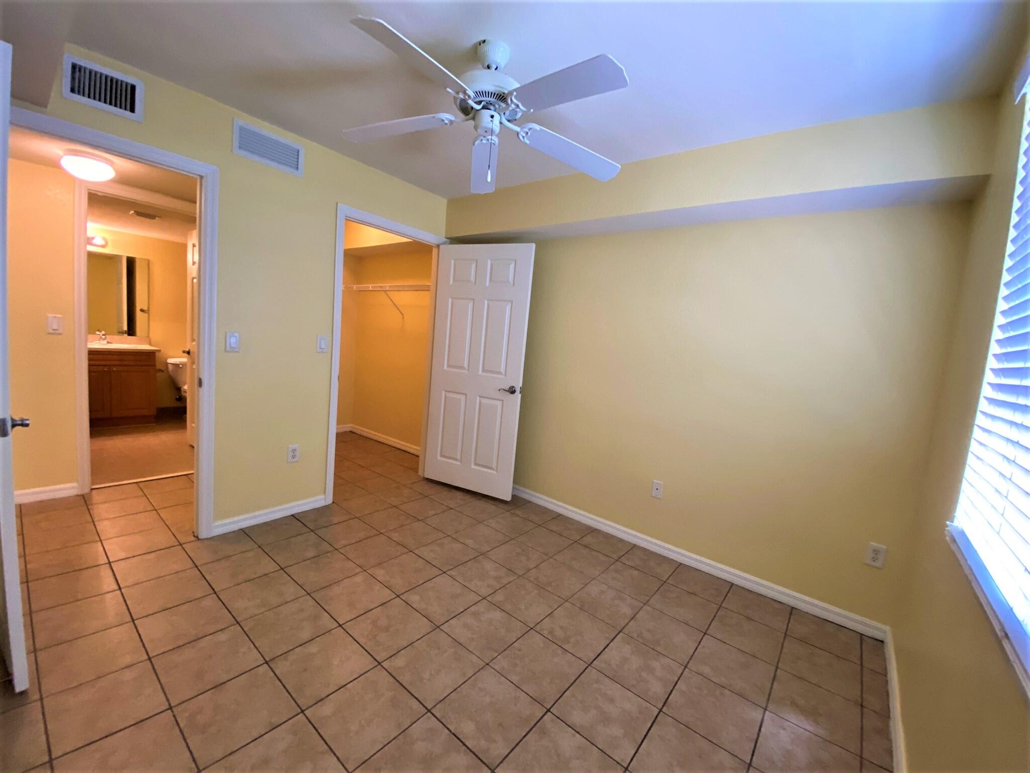 6768 Heritage Grande, Unit 106 Boynton Beach, FL 33437 - Photo 21 of 56 an empty room with a ceiling fan and window