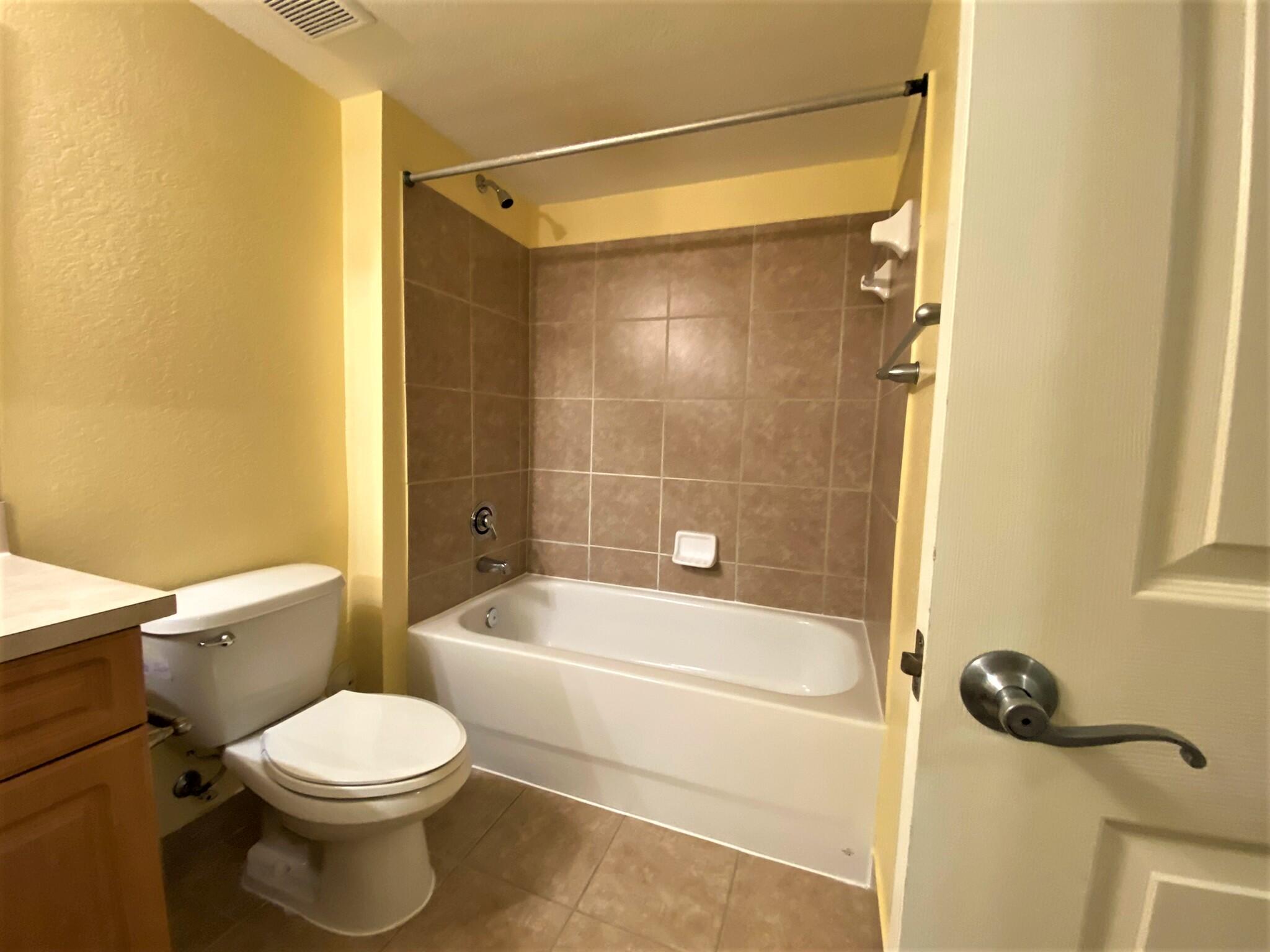 6768 Heritage Grande, Unit 106 Boynton Beach, FL 33437 - Photo 25 of 56 a white toilet sitting next to a bath tub and a shower
