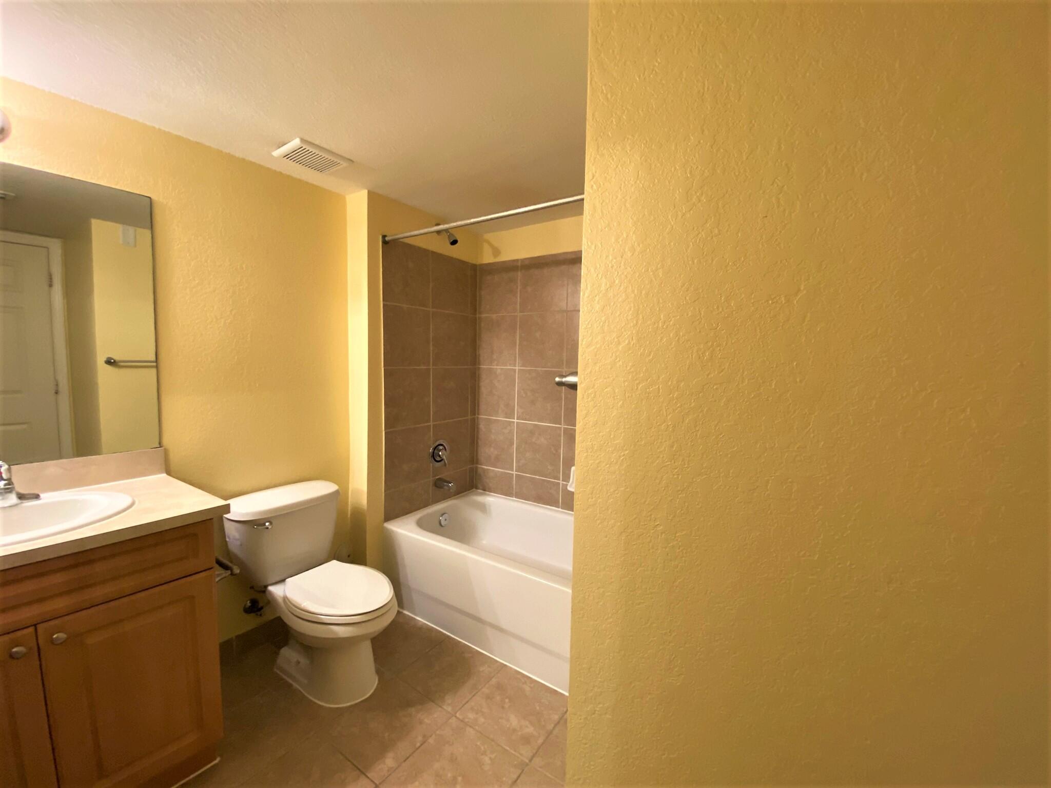 6768 Heritage Grande, Unit 106 Boynton Beach, FL 33437 - Photo 26 of 56 a bathroom with a granite countertop sink toilet and shower