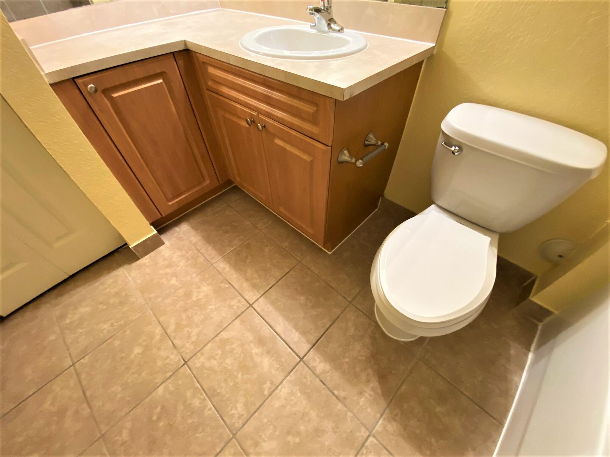 6768 Heritage Grande, Unit 106 Boynton Beach, FL 33437 - Photo 27 of 56 a white toilet sitting next to a bathroom sink