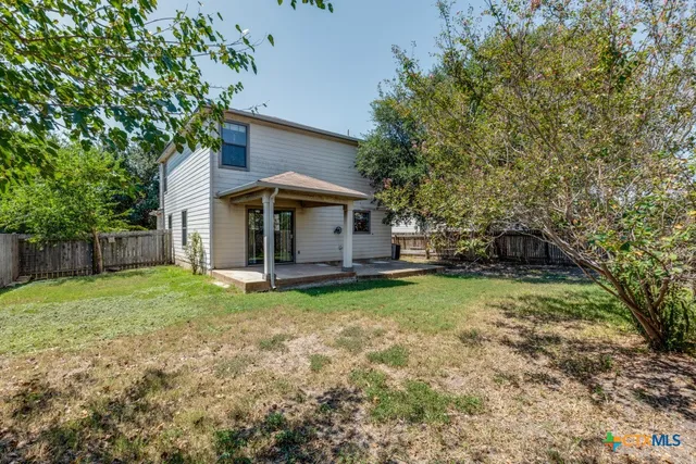 a view of a house with backyard and sitting area