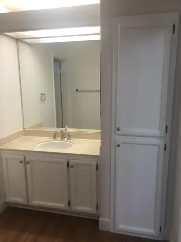 a bathroom with a granite countertop sink and a mirror