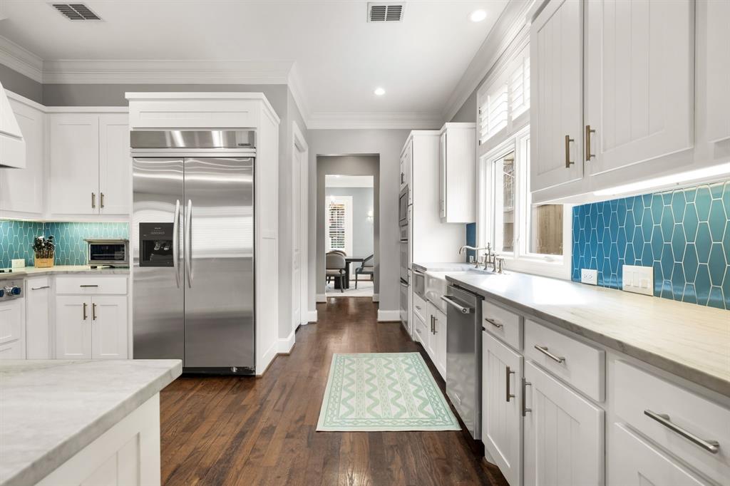 4715 Purdue Avenue Dallas, TX 75209 - Photo 7 of 30 a large kitchen with a refrigerator a sink dishwasher stove and white cabinets