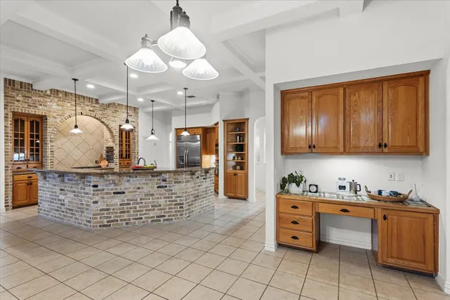 a kitchen with stainless steel appliances kitchen island granite countertop a stove a sink and a refrigerator