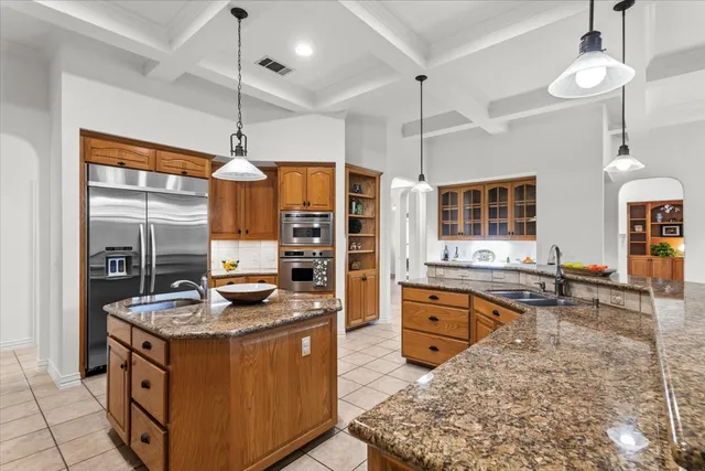 a kitchen with stainless steel appliances granite countertop a stove refrigerator and sink