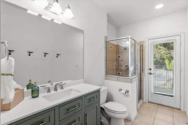 a bathroom with a granite countertop sink a toilet and a mirror
